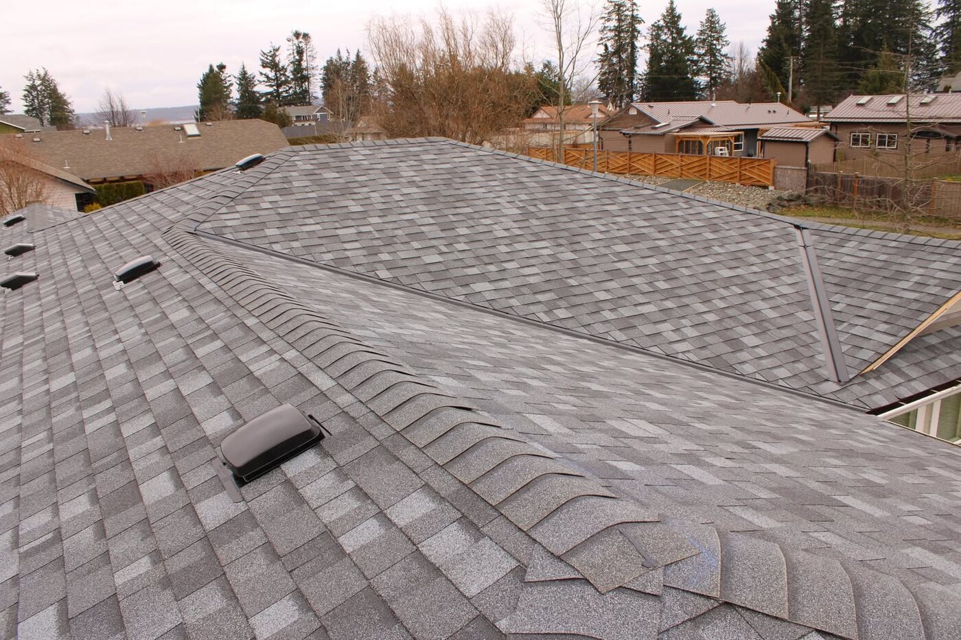 Completed grey architectural shingle roof with hips and valleys
